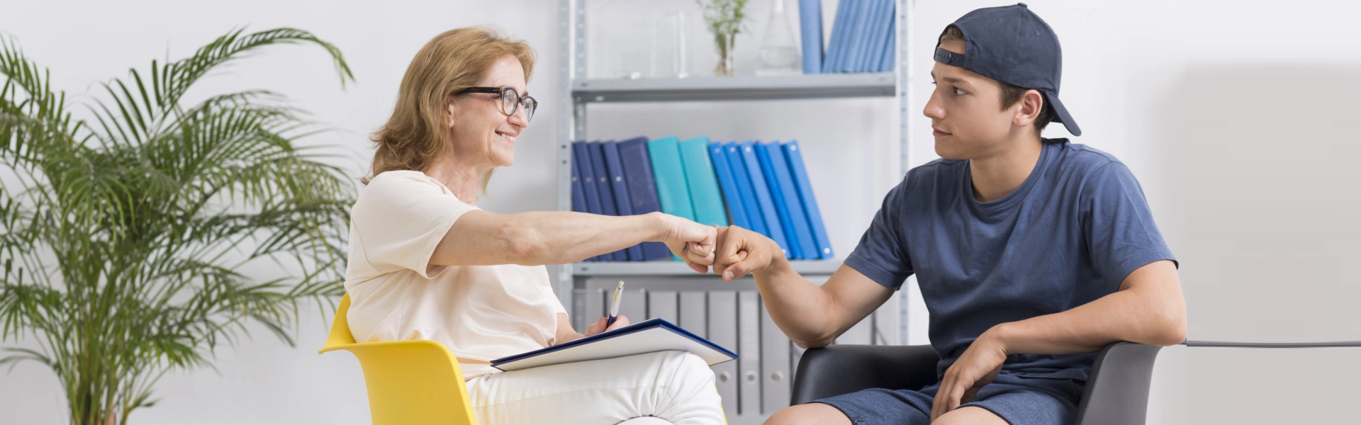 a woman and young man doing a fist bump